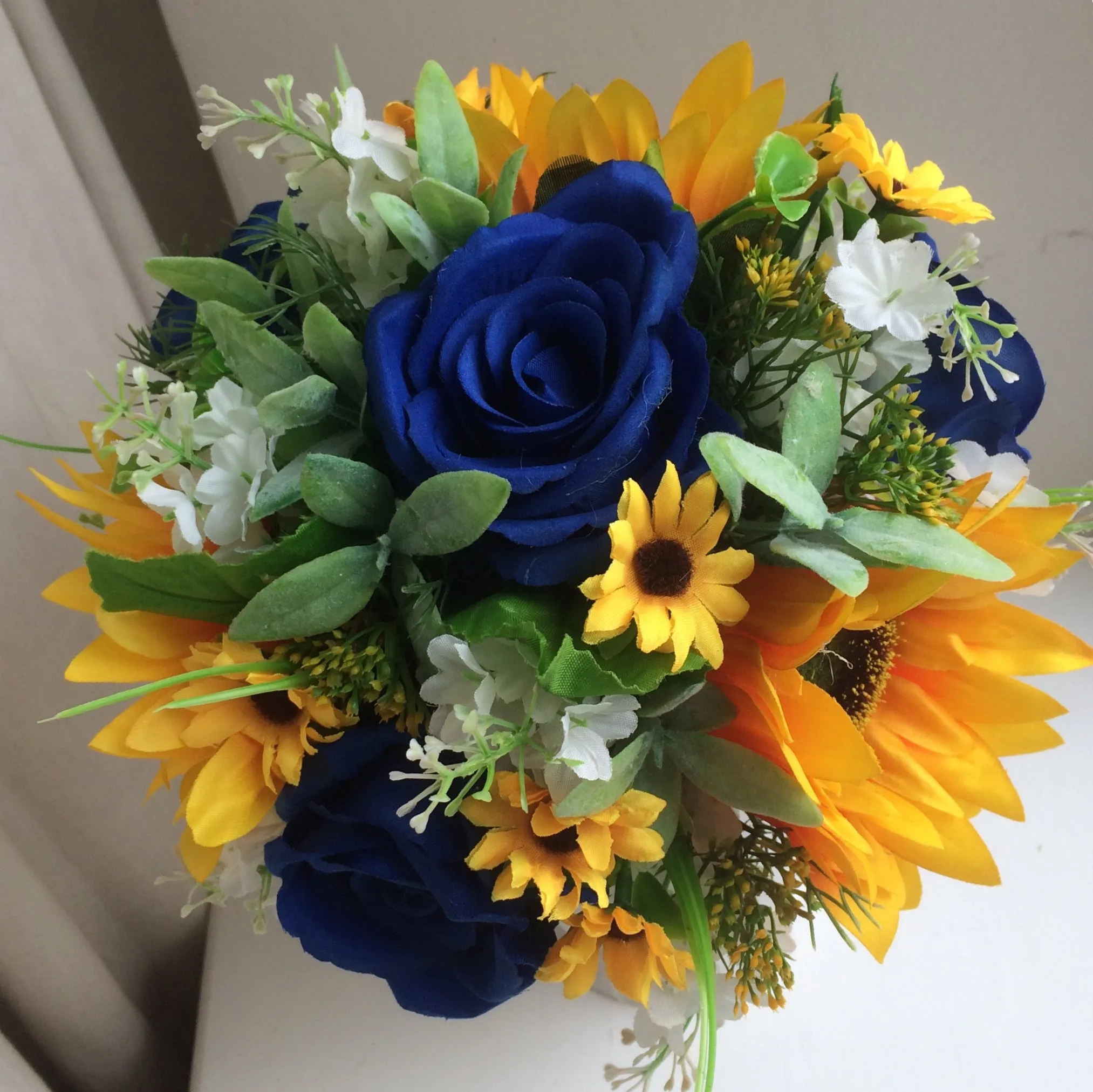 A collection of wedding bouquets featuring  sunflowers and either royal or navy blue roses