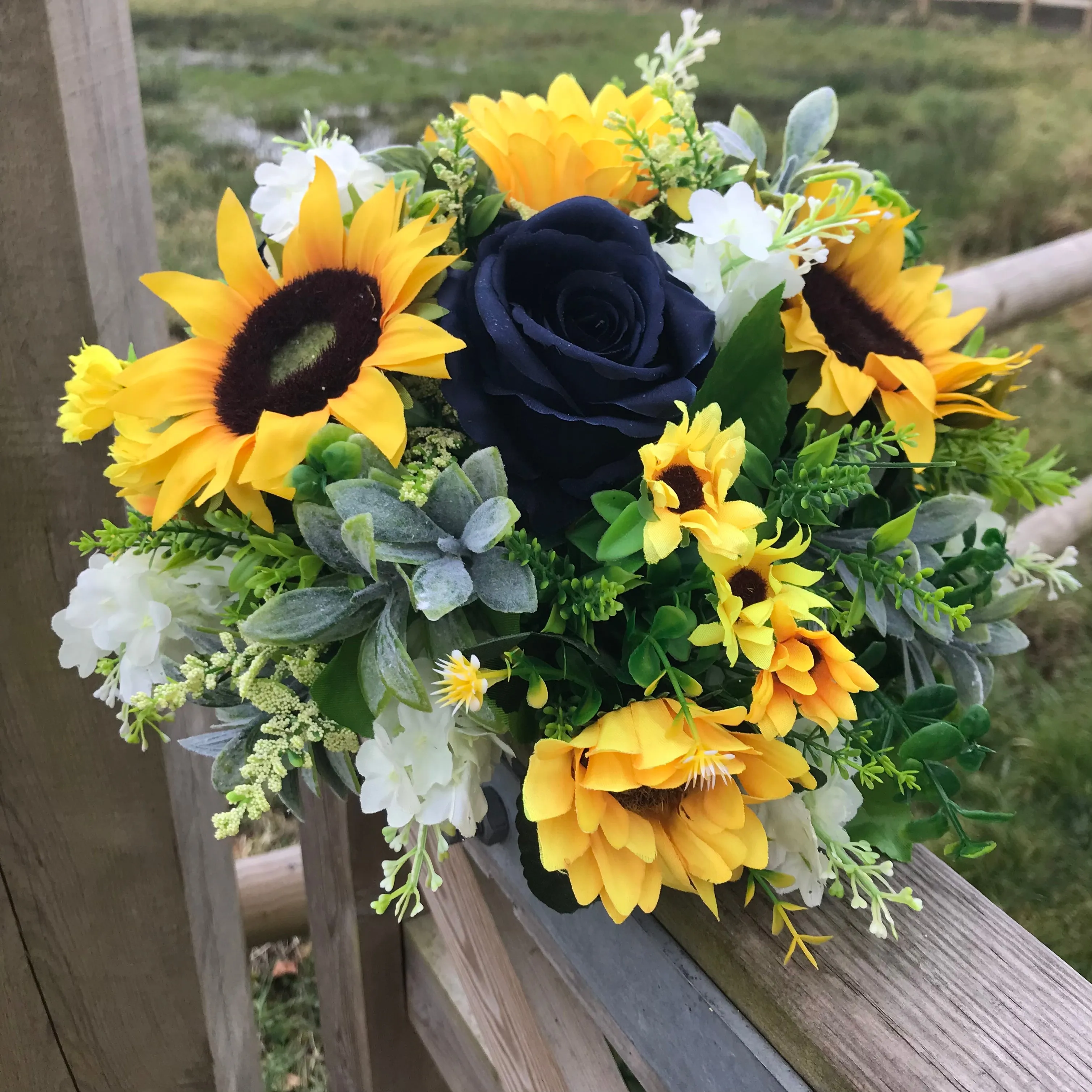 A collection of wedding bouquets featuring  sunflowers and either royal or navy blue roses