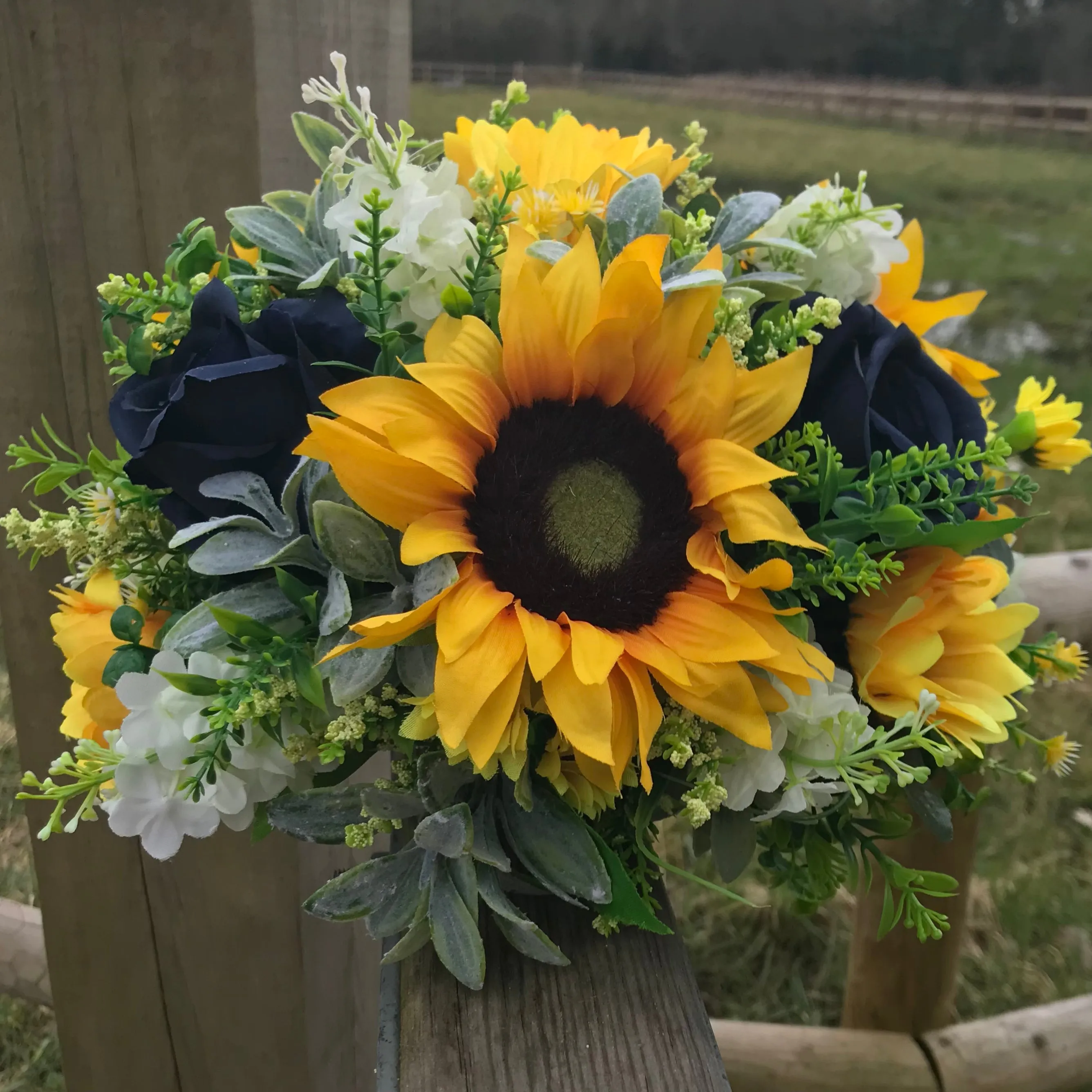 A collection of wedding bouquets featuring  sunflowers and either royal or navy blue roses