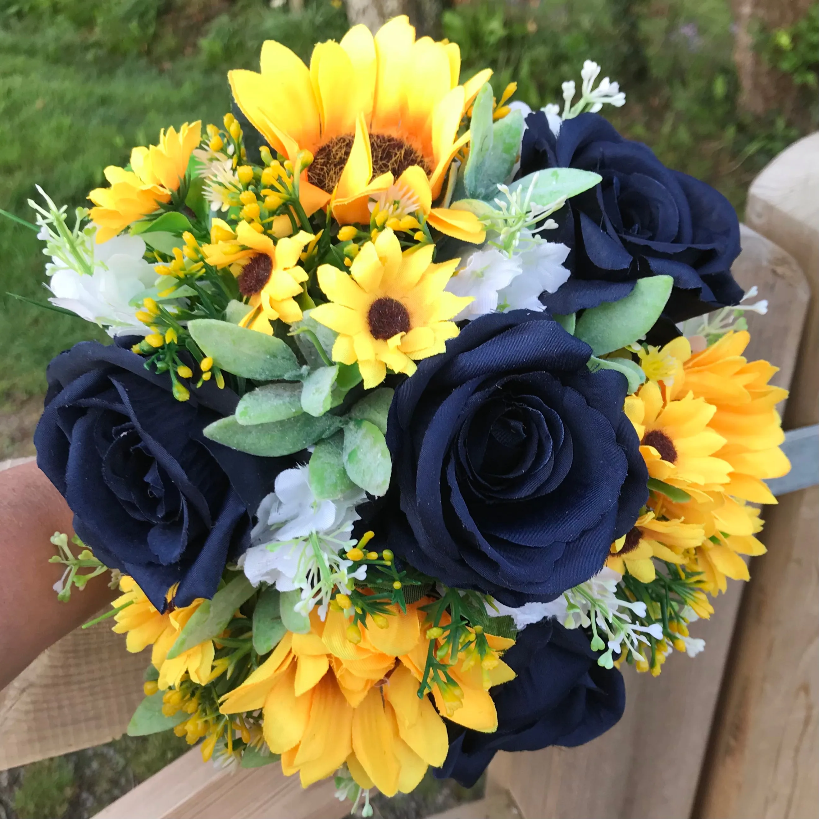 A collection of wedding bouquets featuring  sunflowers and either royal or navy blue roses