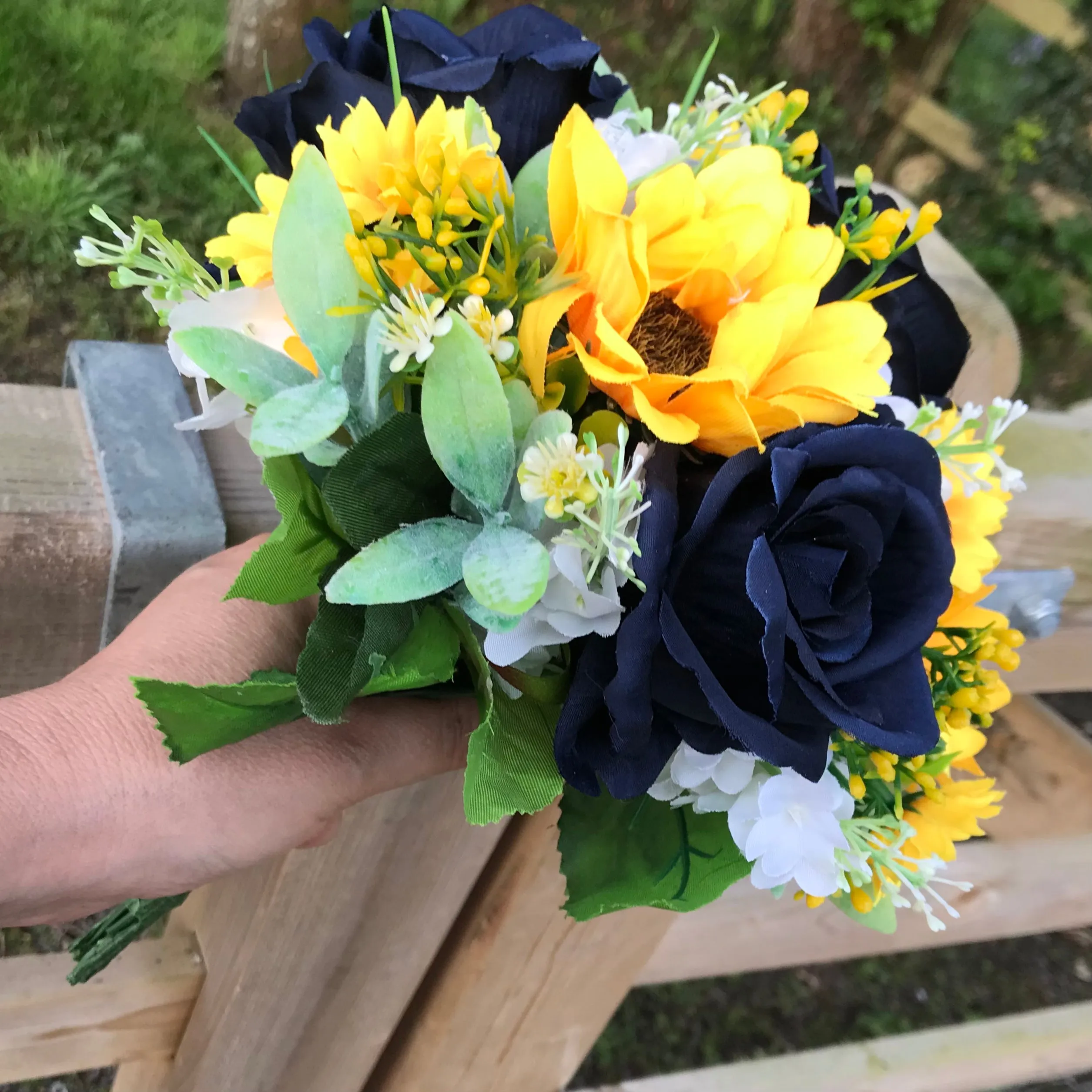 A collection of wedding bouquets featuring  sunflowers and either royal or navy blue roses